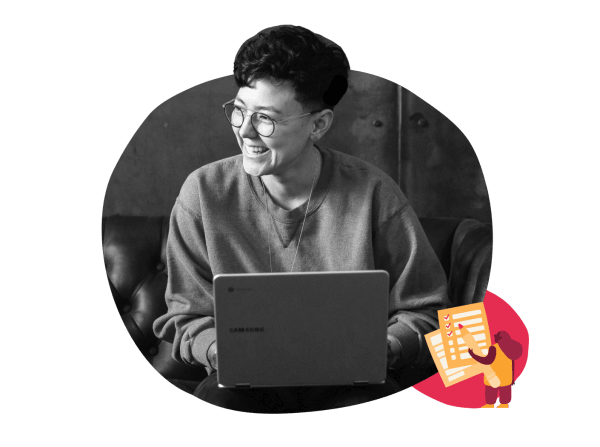 smiling person using a laptop in casual attire, modern workspace with creative elements and joyful atmosphere